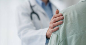 doctor holding patients shoulder with comfort
